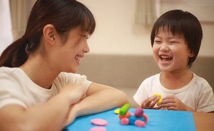 Educator playing with child at a table