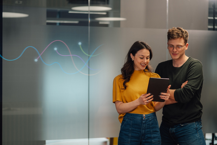 Young professionals analyzing data on tablet in modern office