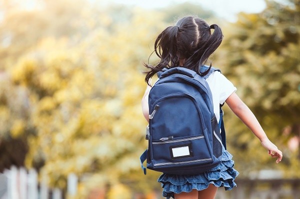 School child running with backpack