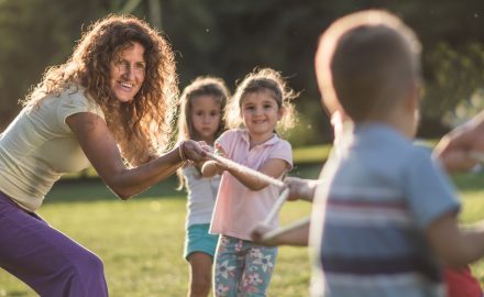 Educator and children playing tug-of-war