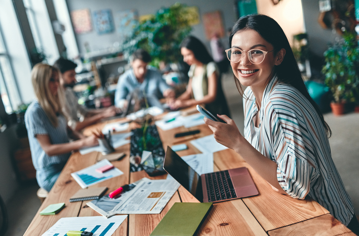 Educator sitting at a table smiling at the camera
