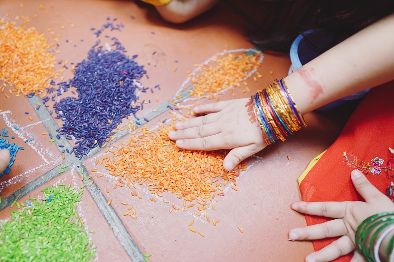 Close up on a child's hand moving coloured rice