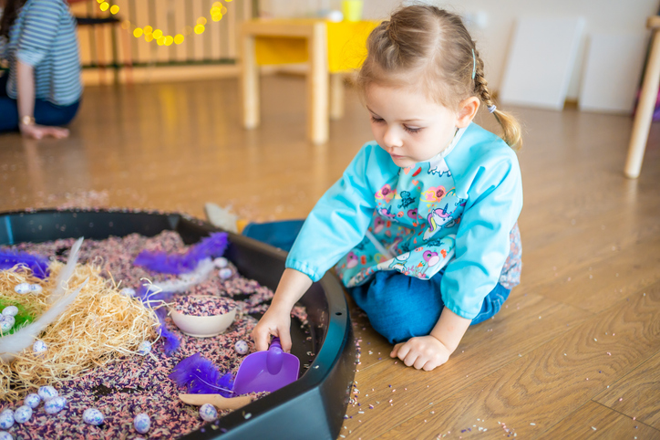 Child playing with colourful rice