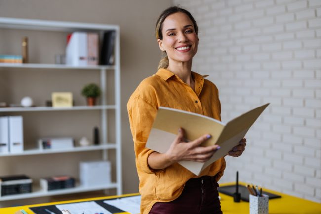 Educator holding document and smiling