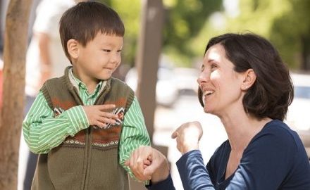 Educator and child communicating with sign language