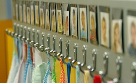 Hooks with children's pictures above to help them identify which hooks belongs to them