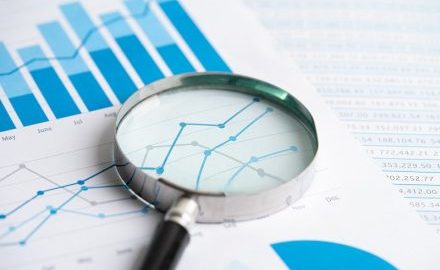 Magnifying glass resting on a document with a line graph