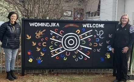 Californian Gully Kindergarten staff member and mural artist standing next to First Nations mural