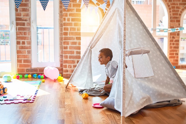 Child playing in a fabric teepee