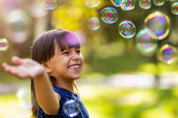 Child playing happily with bubbles