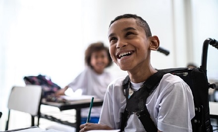 Child sitting in wheelchair smiling