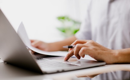 Hands typing on a laptop