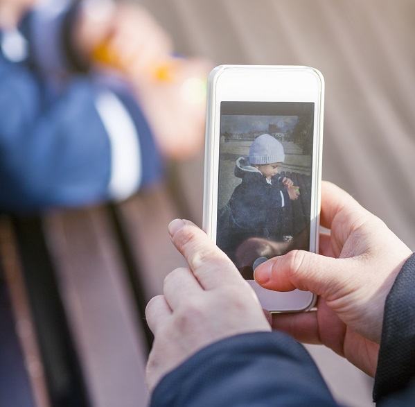 Person taking photo of child with their phone