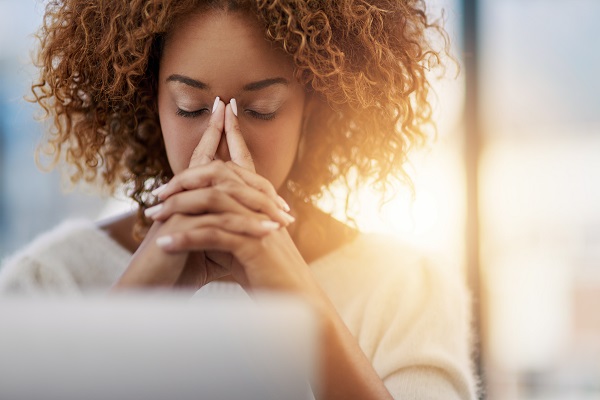 Educator with head resting in hands, looking stressed