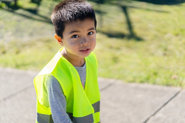 Child wearing a high-vis vest walking on a path