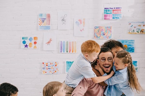 A group of children hugging an educator