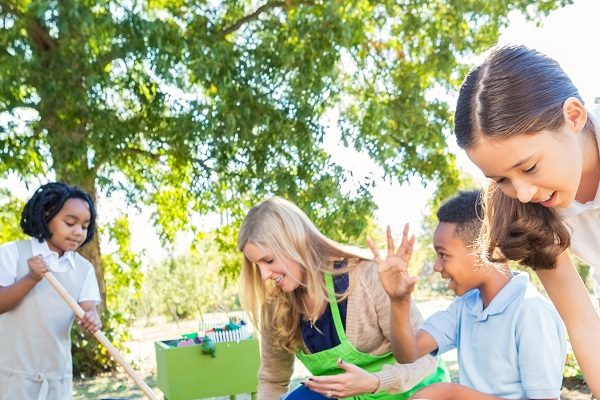 Children gardening with educator