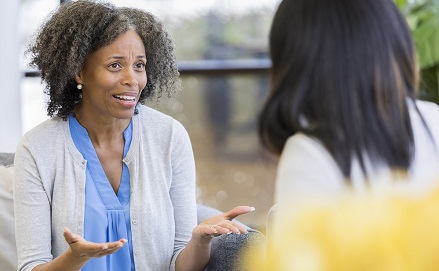 Woman speaking to another person who has their back to the camera