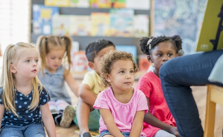 Group of children sitting on the floor being read to