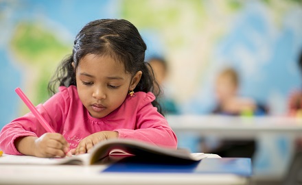 Child colouring at a desk