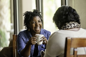 Two educators in conversation and enjoying a cup of tea together
