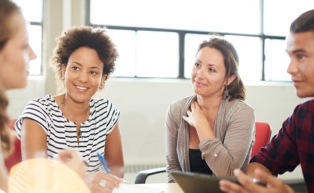 Group of four people sitting around a table in a discussion
