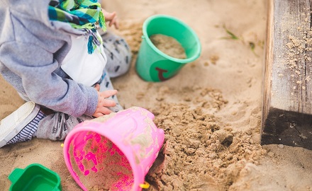 Child playing with buckets in the sandpit